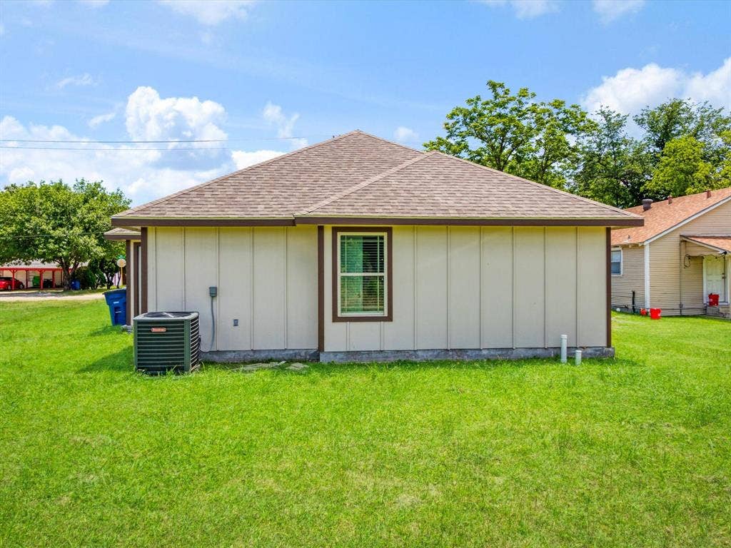 Exterior featuring vertical siding, a hip roof with asphalt shingles, and an outdoor HVAC unit