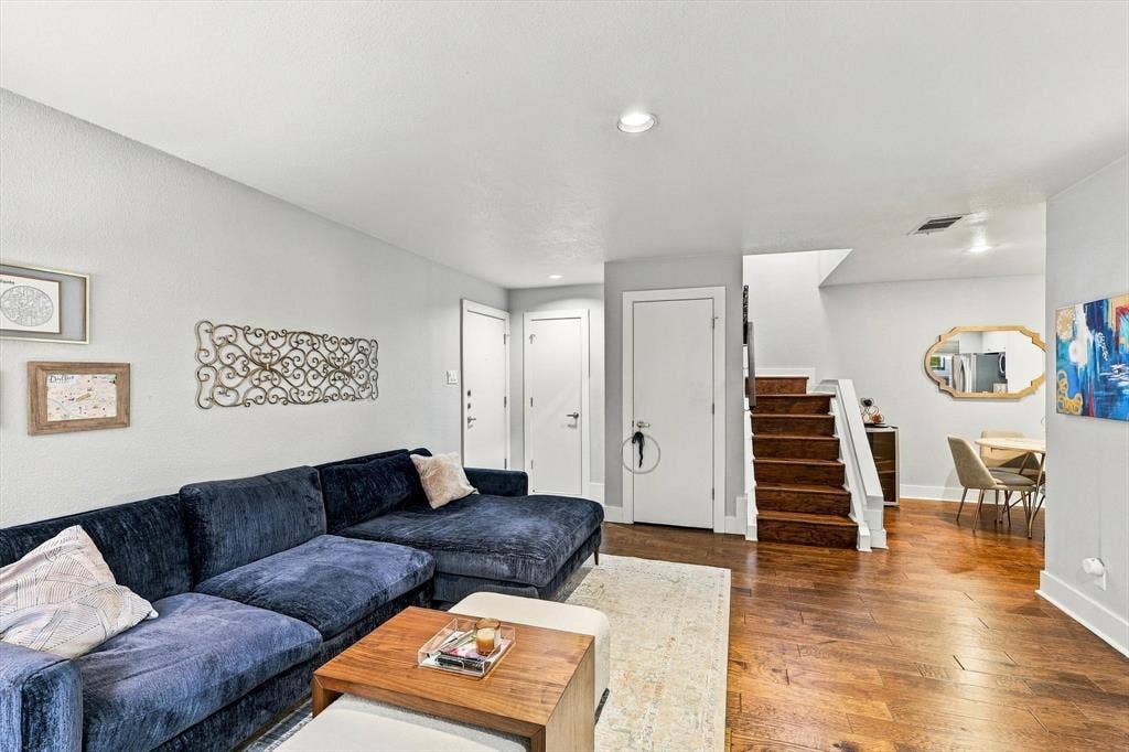 4777 Cedar Springs Road, #9K, Dallas, TX 75219 Open floor plan featuring wood-finish flooring, recessed lighting, and a staircase with wood treads and a white balustrade