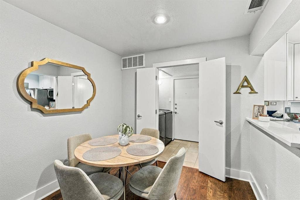 4777 Cedar Springs Road, #9K, Dallas, TX 75219 Dining area featuring wood-finish flooring, recessed lighting, and a kitchen pass-through counter with a stone-surface finish