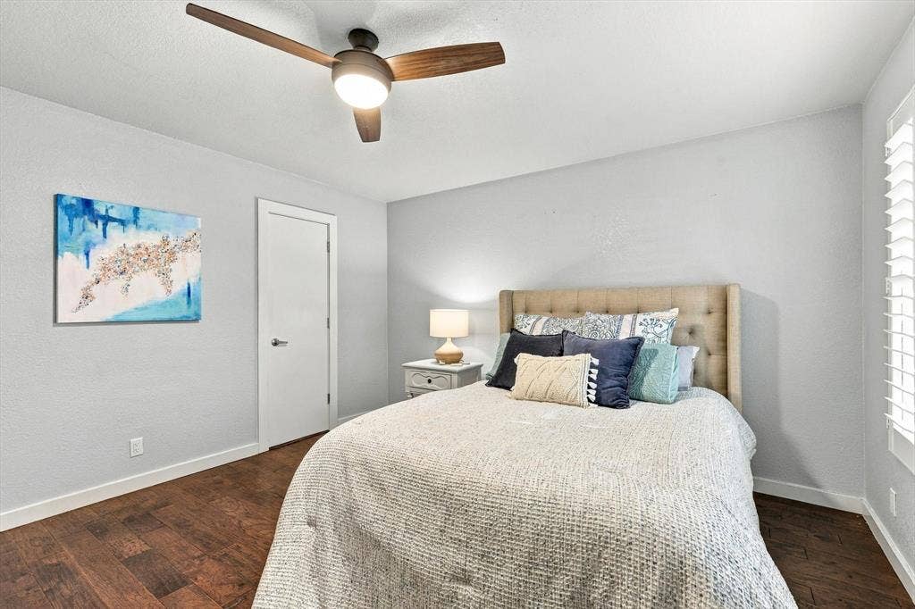 4777 Cedar Springs Road, #9K, Dallas, TX 75219 Room featuring wood-finish flooring, a modern three-blade ceiling fan with integrated lighting, and plantation-style window shutters