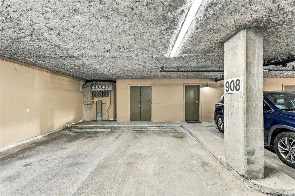 4777 Cedar Springs Road, #9K, Dallas, TX 75219 DIRECT ACCESS TO CONDO Covered parking area featuring concrete flooring, structural support columns, ceiling-mounted linear lighting, and direct building access