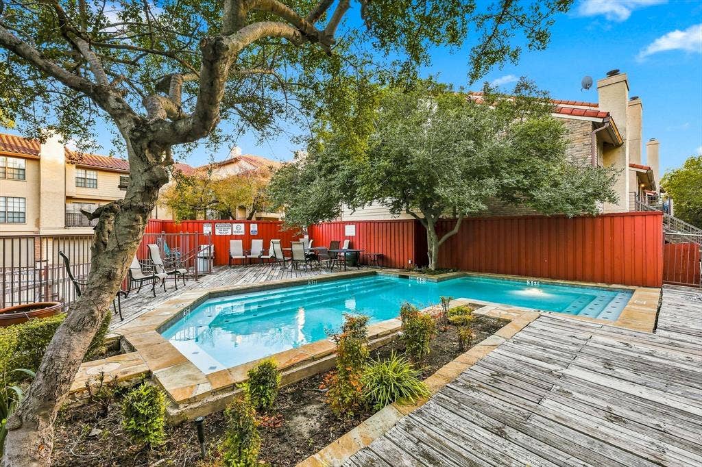 4777 Cedar Springs Road, #9K, Dallas, TX 75219 Community swimming pool featuring a tiered stone coping, integrated stepped entry, wood decking, and mature landscaping