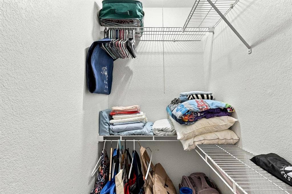 4777 Cedar Springs Road, #9K, Dallas, TX 75219 Storage area featuring tiered white wire shelving and a horizontal hanging rod
