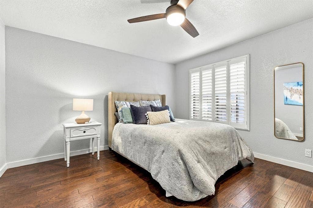 4777 Cedar Springs Road, #9K, Dallas, TX 75219 Room featuring wood-finish flooring, plantation shutters, and a central ceiling fan with an integrated light fixture