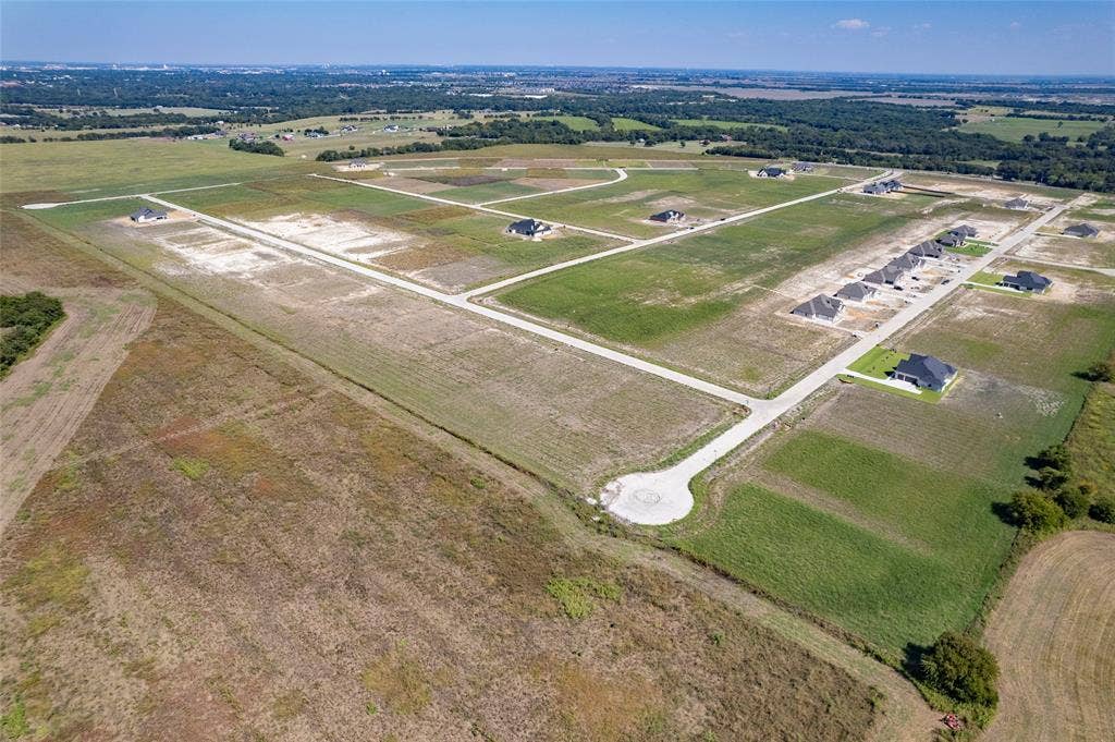 109 Devi Drive, Waxahachie, TX 75165 Aerial perspective of a master-planned community featuring concrete cul-de-sacs, paved roads, and expansive undeveloped lots