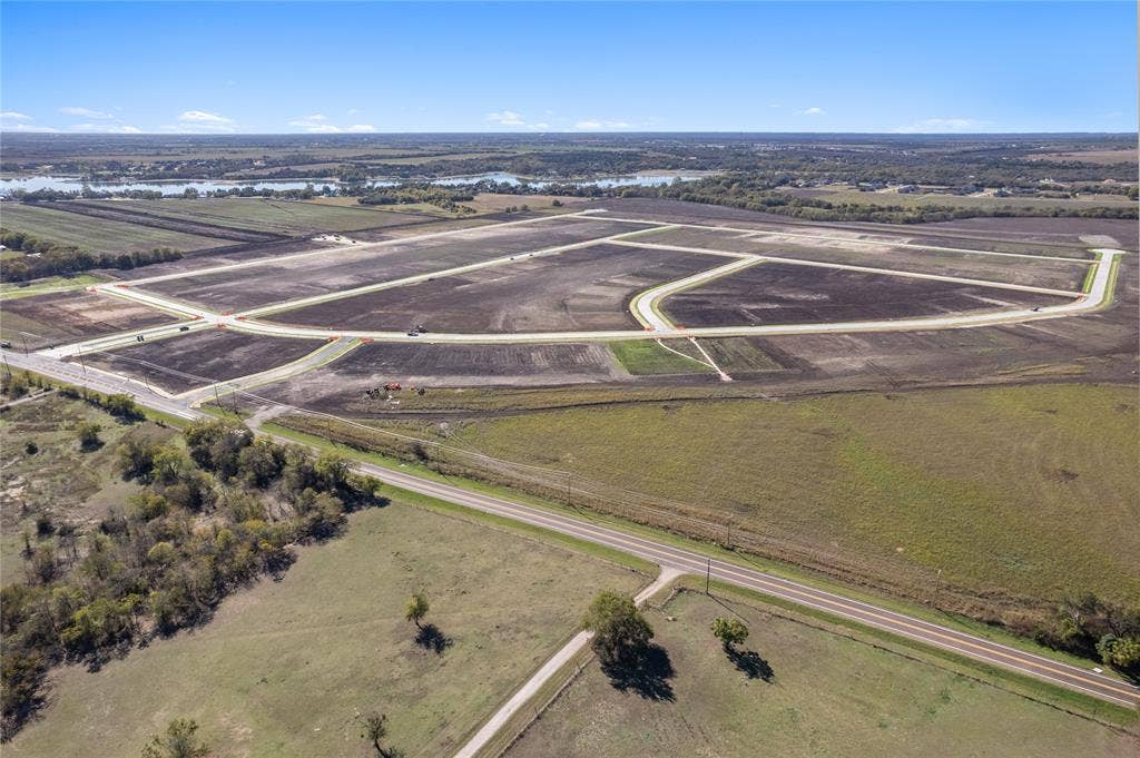 109 Devi Drive, Waxahachie, TX 75165 Expansive undeveloped acreage featuring paved roadways, curb infrastructure, and horizon water scenery
