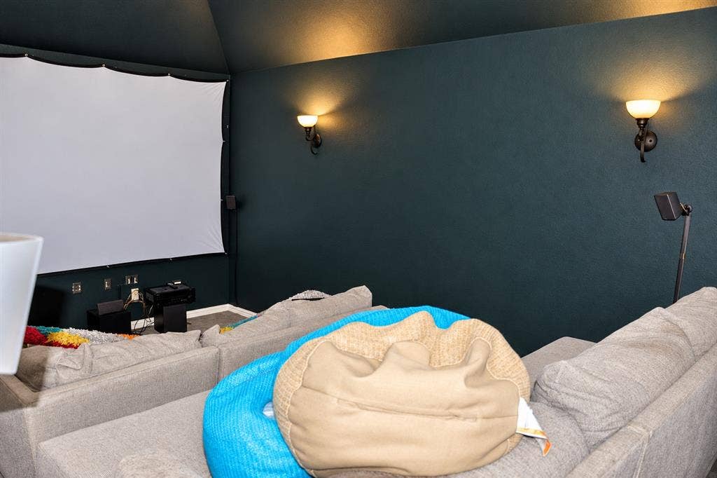 3620 Carlton Court, Sachse, TX 75048 Media room featuring a vaulted ceiling and wall-mounted metal sconces
