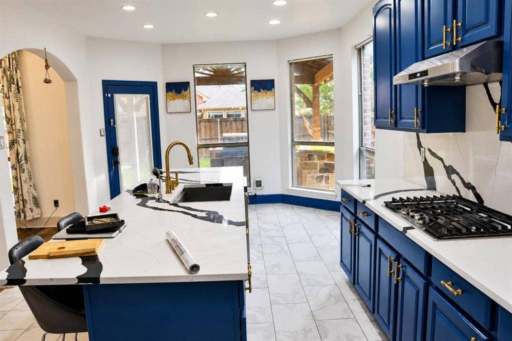 3620 Carlton Court, Sachse, TX 75048 Kitchen featuring blue cabinetry with gold-tone hardware, white countertops with veining, a stainless steel gas cooktop, and tile flooring