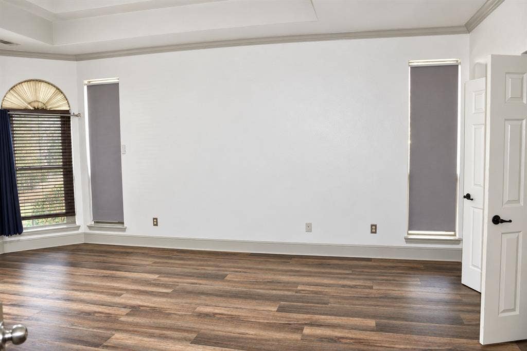 3620 Carlton Court, Sachse, TX 75048 Tray ceiling, wood-finish flooring, and multi-pane windows with arched transom