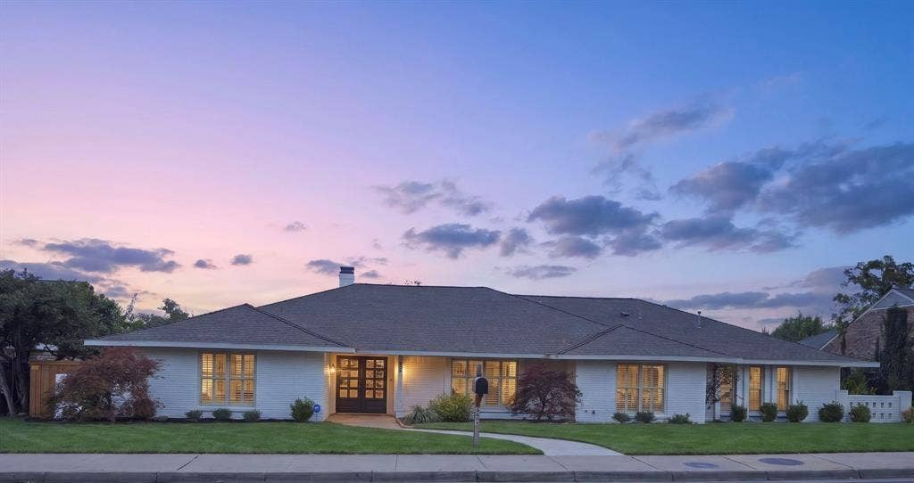 6978 Pemberton Drive, Dallas, TX 75230 Single-story brick exterior featuring a low-pitched roof, multi-pane double front doors, large divided-light windows, and a paved walkway