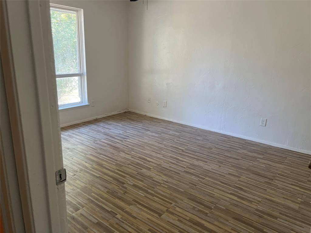 5005 Highridge Drive, Garland, TX 75043 Room interior featuring wood-finish flooring, white walls, and a single-hung window