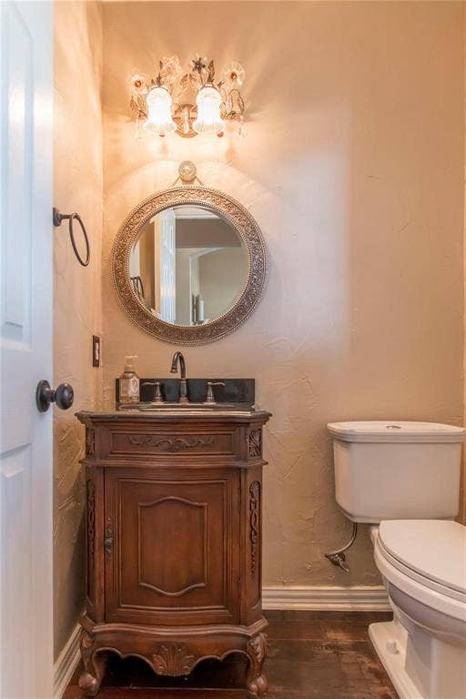 12004 Paducah Drive, Frisco, TX 75035 Chic half bath with wood vanity and decorative round mirror.