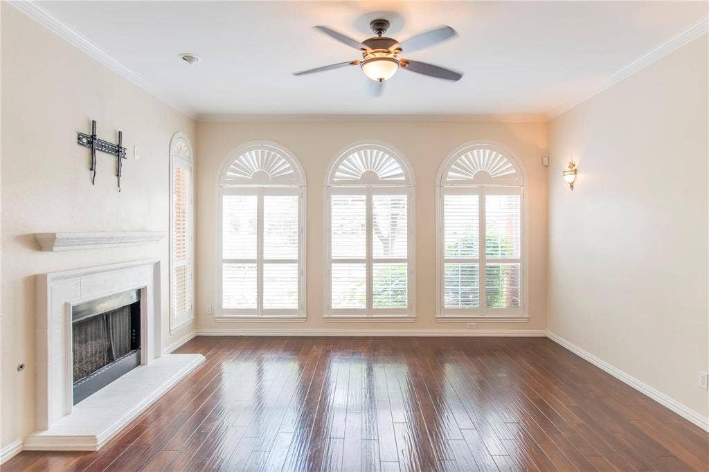 12004 Paducah Drive, Frisco, TX 75035 Inviting living room with fireplace, ceiling fan and arched windows - move-in ready!