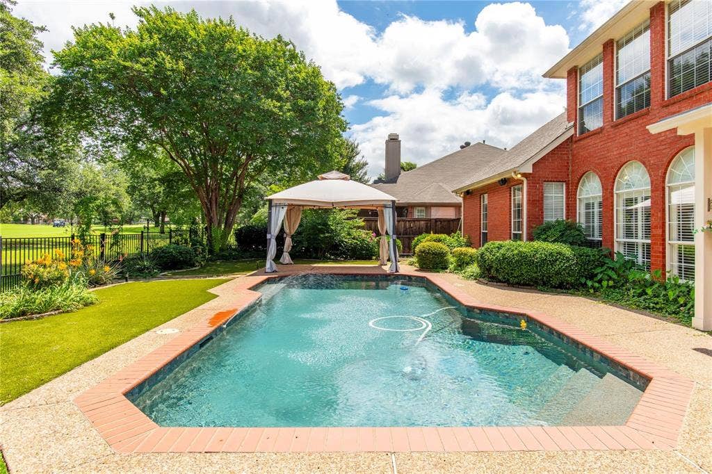 12004 Paducah Drive, Frisco, TX 75035 Sparkling pool surrounded by lush green lawn and mature trees - summer fun right at home.