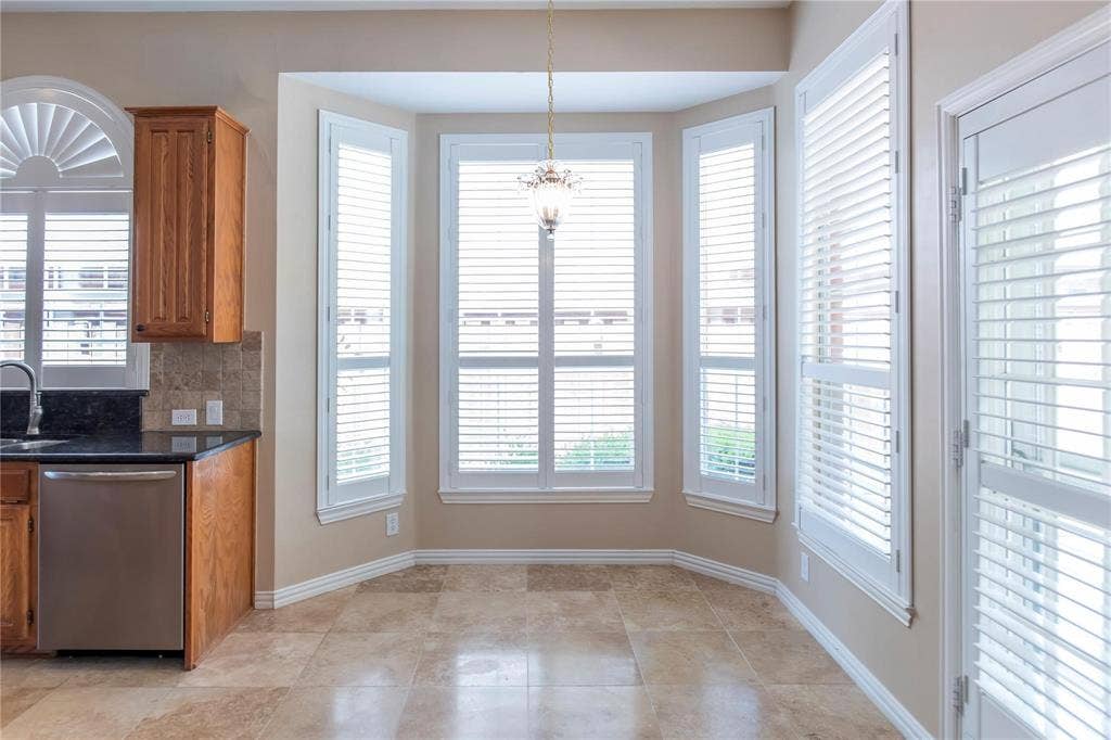 12004 Paducah Drive, Frisco, TX 75035 Light-filled dining area with a wall of windows and plantation shutters, open to the kitchen.