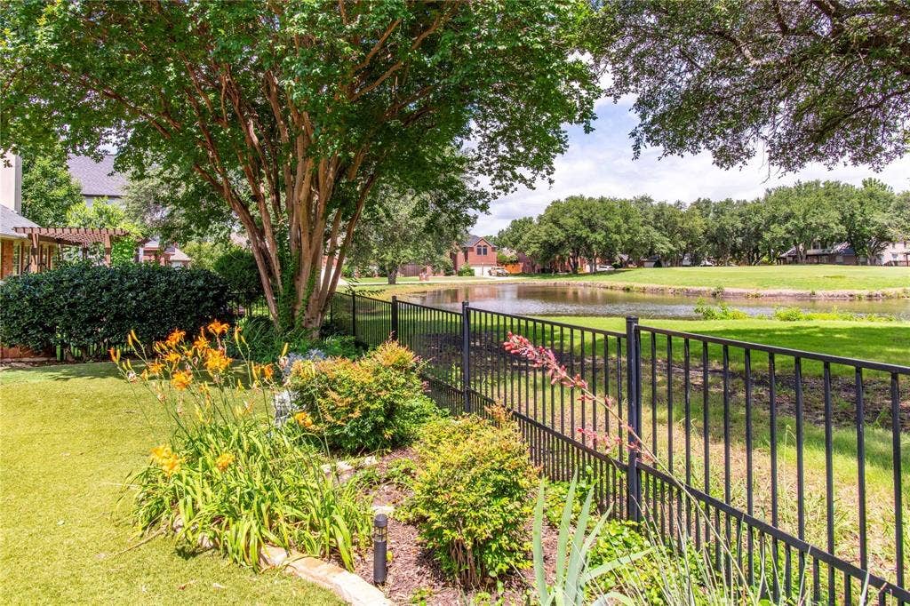 12004 Paducah Drive, Frisco, TX 75035 Beautifully landscaped yard with wrought-iron fencing and peaceful golf course and pond views beyond.
