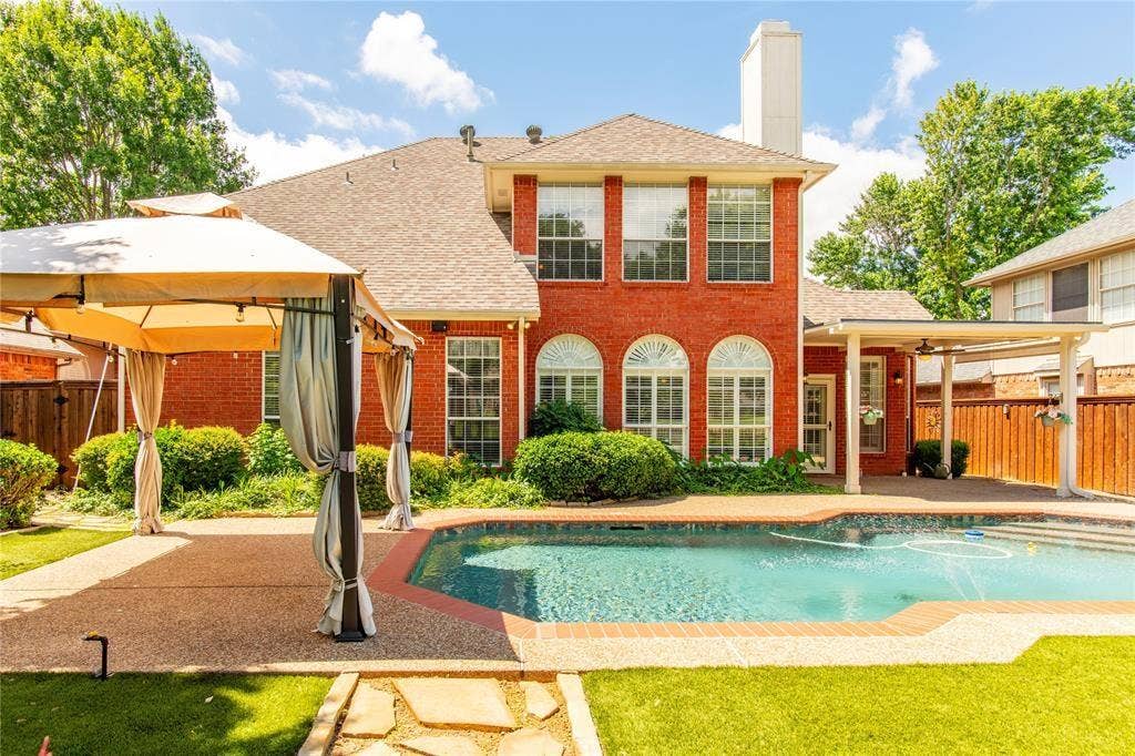 12004 Paducah Drive, Frisco, TX 75035 Entertain in style: covered pergola patio overlooks the pool and lush landscaping - made for summer evenings.