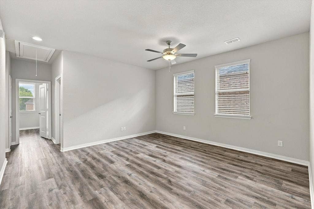 614 Ansley Way, Allen, TX 75013 Wood-finish flooring, neutral wall tones, two dual-pane windows, and a central ceiling fan with integrated lighting
