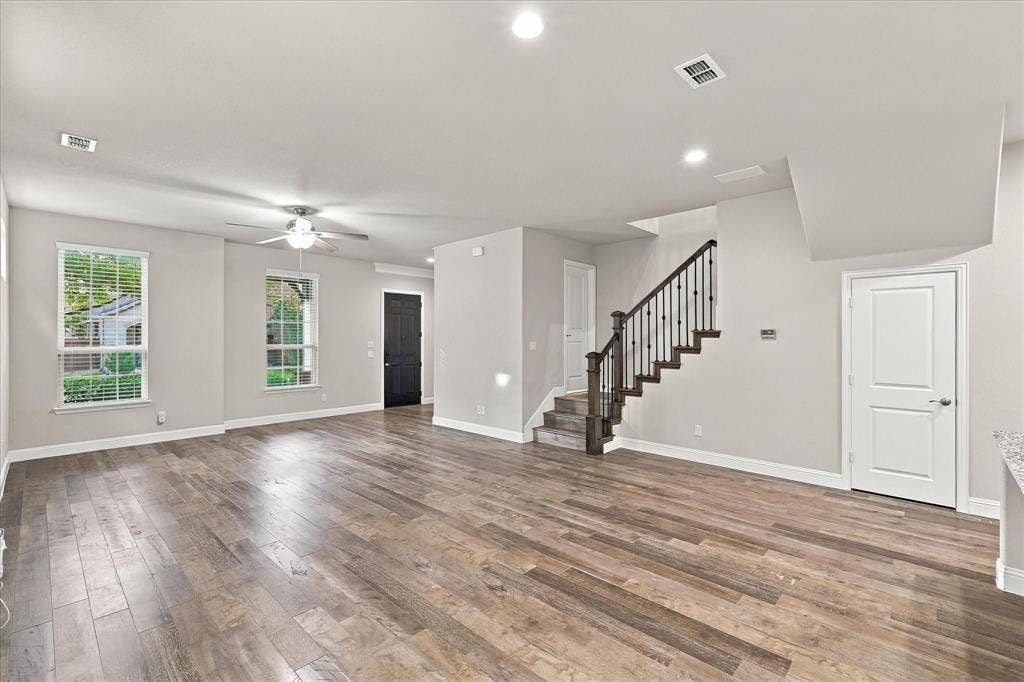 614 Ansley Way, Allen, TX 75013 Open-concept interior featuring wood-finish flooring, recessed lighting, and a staircase with a dark-stained wood handrail and iron balusters