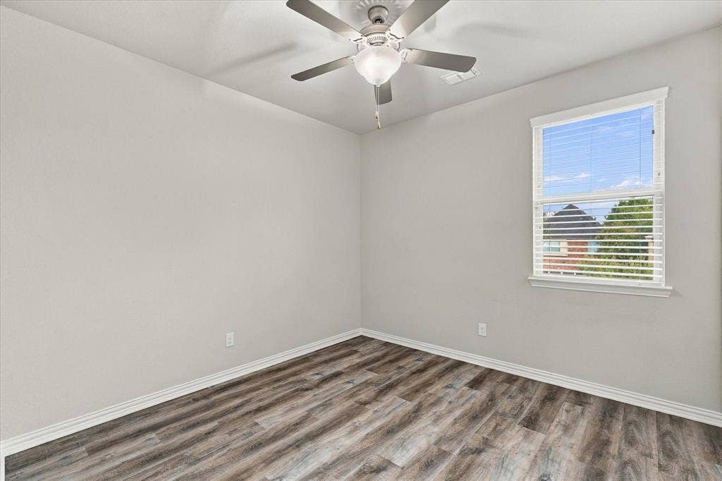 614 Ansley Way, Allen, TX 75013 Neutral-toned interior featuring wood-finish flooring, a ceiling fan with integrated lighting, and a window with horizontal blinds