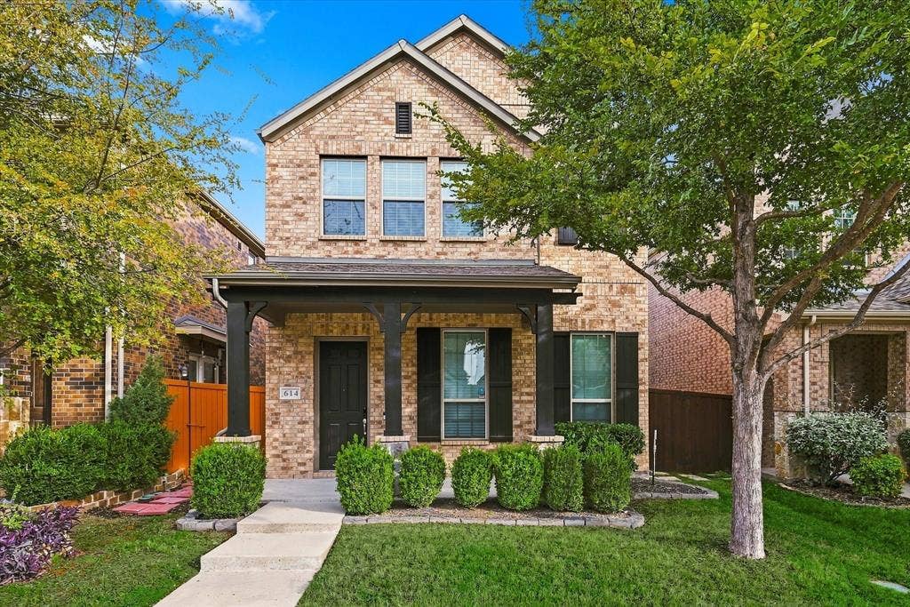 614 Ansley Way, Allen, TX 75013 Multi-story brick exterior featuring a covered front porch, dark-toned architectural columns, black shutters, and manicured landscaping
