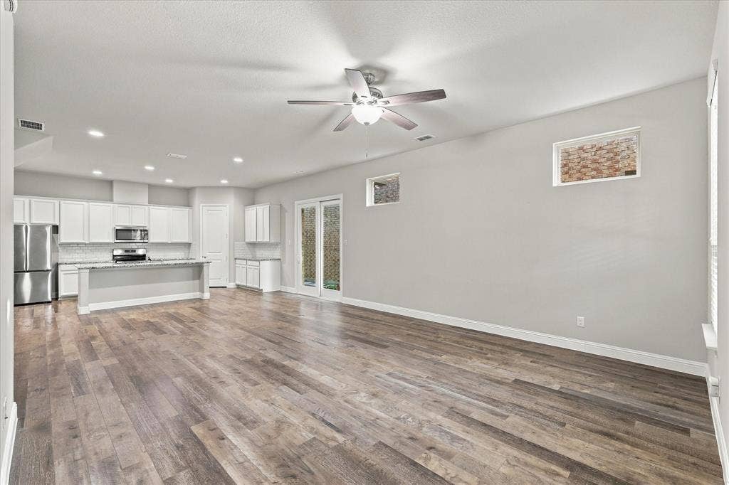 614 Ansley Way, Allen, TX 75013 Open-concept room featuring wood-finish flooring, white cabinetry, recessed lighting, a ceiling fan with integrated light fixture, and glass-paneled exterior doors