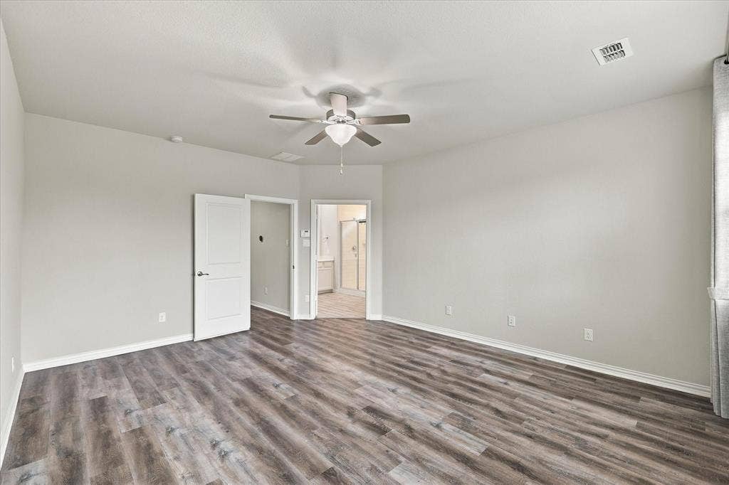 614 Ansley Way, Allen, TX 75013 Neutral-toned room featuring wood-finish flooring, a multi-blade ceiling fan with integrated lighting, and solid-core interior doors