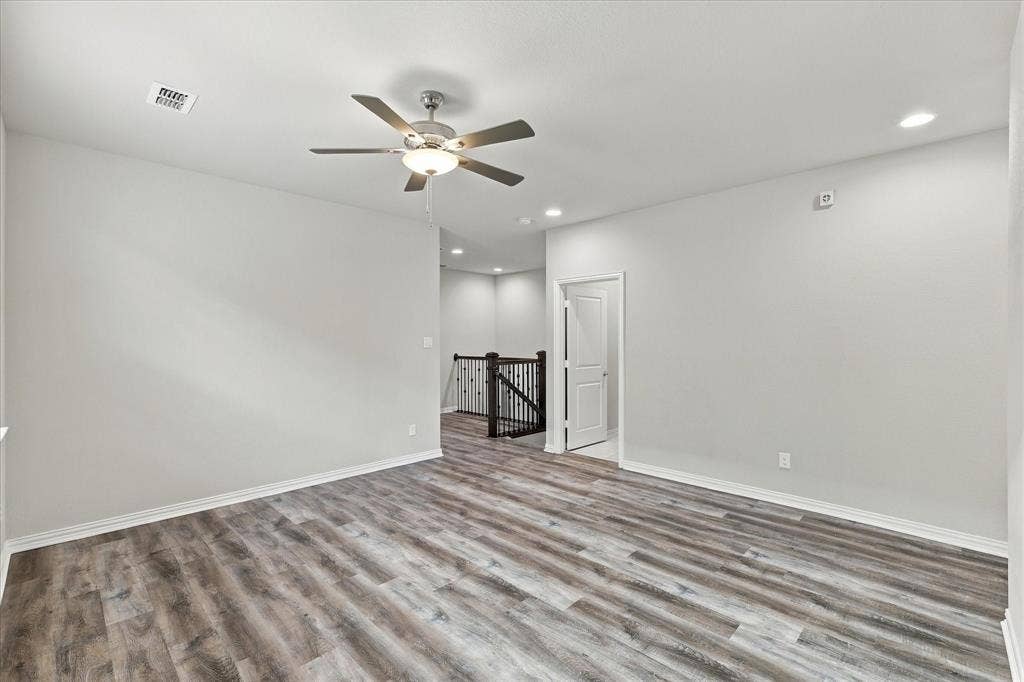 614 Ansley Way, Allen, TX 75013 Interior room featuring wood-finish flooring, a multi-blade ceiling fan with integrated lighting, recessed ceiling lights, and iron stair railing