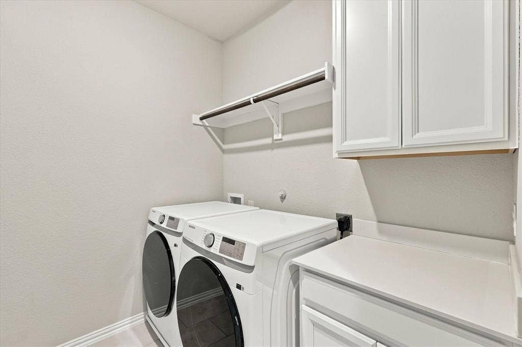 614 Ansley Way, Allen, TX 75013 Laundry area featuring shaker-style white cabinetry, solid-surface countertop, and an integrated hanging rod with shelving