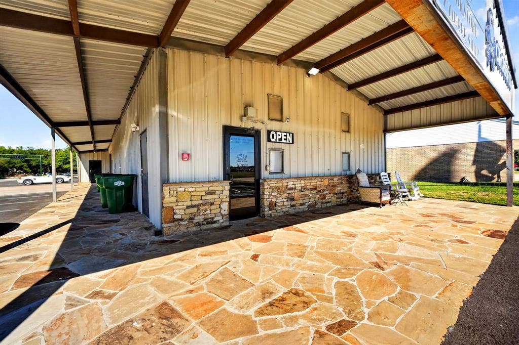 911 W Holiday Drive, Fate, TX 75132 Metal-clad exterior featuring a flagstone patio, covered porch, and stone facade accents