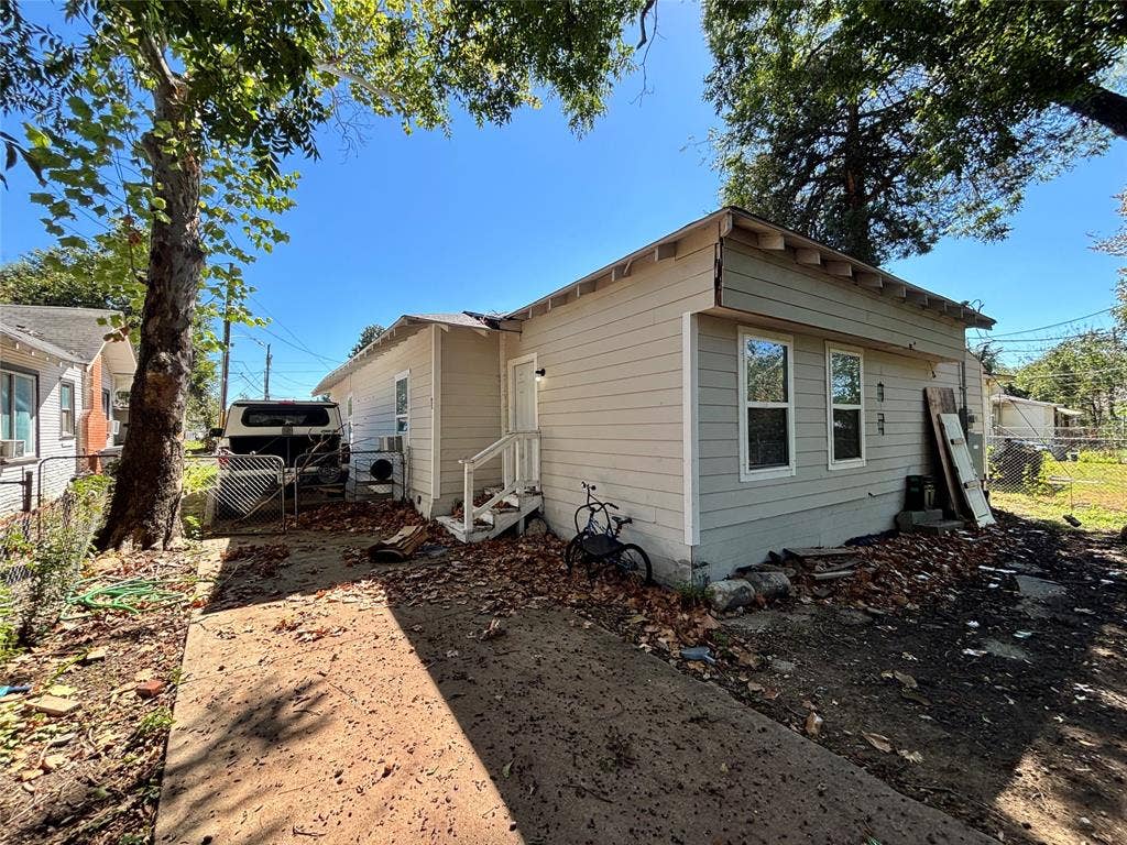 2917 Lenway Street, Dallas, TX 75215 Single-story exterior featuring light-toned horizontal siding, exposed rafter tails, and a concrete driveway