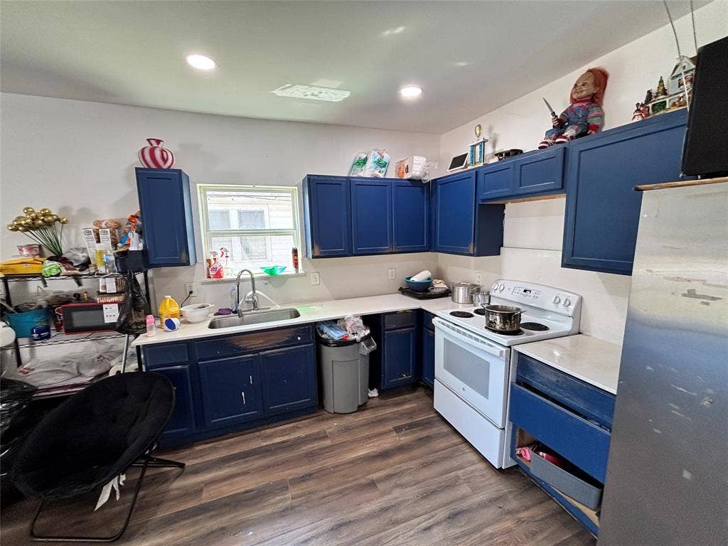 2917 Lenway Street, Dallas, TX 75215 Kitchen featuring navy cabinetry, solid-surface countertops, wood-finish flooring, recessed lighting, and a stainless steel sink with a high-arch faucet