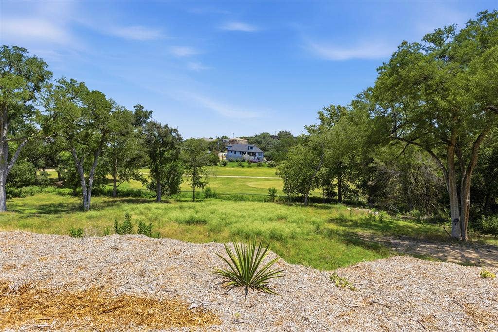 Expansive lot featuring mature hardwood trees and open green space