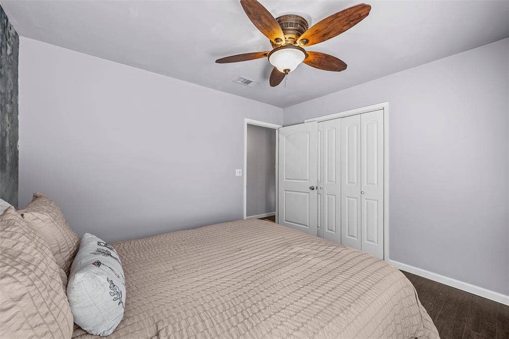 Room featuring wood-finish flooring, a ceiling fan with integrated lighting, and a bifold closet door