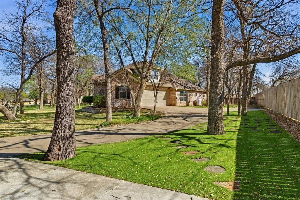 3714 Cove Timber Avenue, Granbury, TX 76049 Lots of room to park and extra for your boat. Turf has been added here for low maintenance.