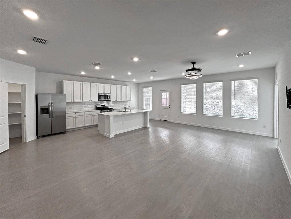 2504 Clyde Road, Celina, TX 75009 Open-concept living, breakfast nook and kitchen features white cabinetry, a center island, stainless steel appliances, recessed lighting, and luxury vinyl plank flooring