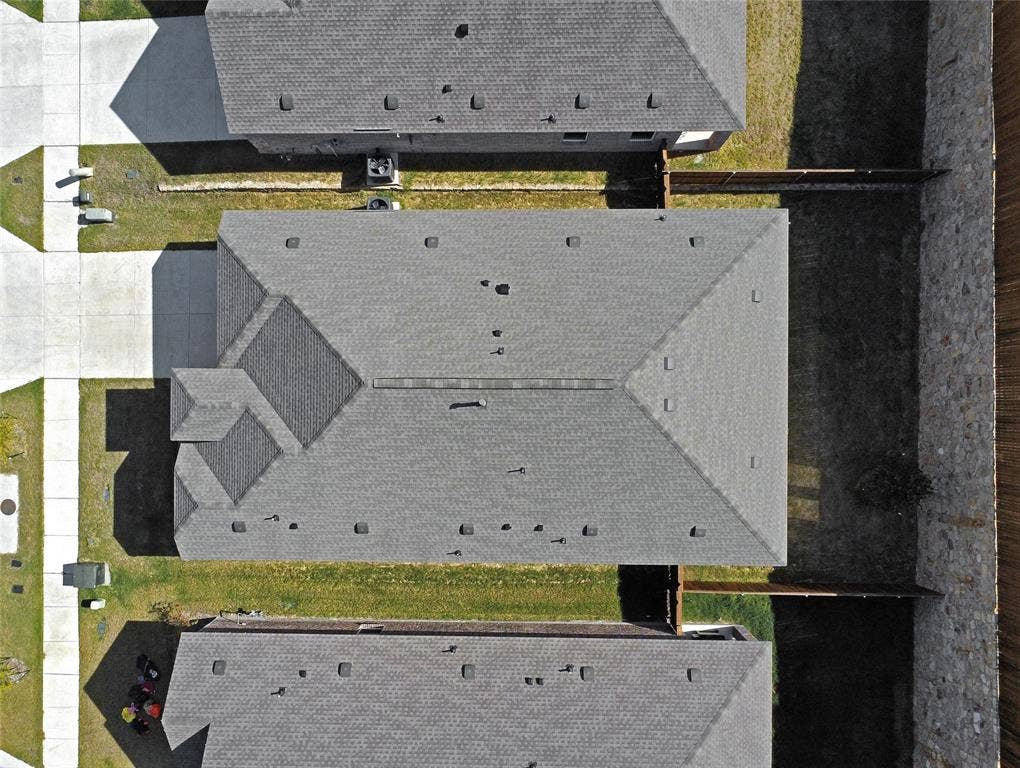 2504 Clyde Road, Celina, TX 75009 Aerial view of the residential property featuring a composition shingle roof, concrete driveway, and stone and wood perimeter fencing