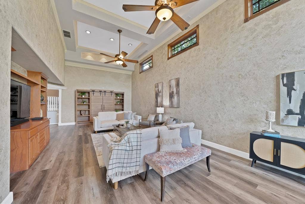 306 E Rochelle Boulevard, Irving, TX 75062 High ceilings with tray architectural detail, wood-finish flooring, built-in wooden cabinetry, transom windows, and dual ceiling fans