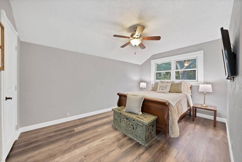 306 E Rochelle Boulevard, Irving, TX 75062 Room featuring wood-finish flooring, a vaulted ceiling, a ceiling fan with integrated lighting, and dual-pane windows