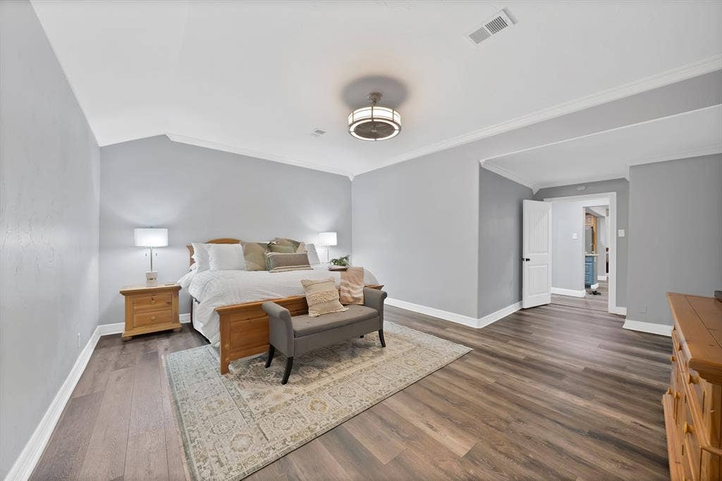 306 E Rochelle Boulevard, Irving, TX 75062 Wood-finish flooring, vaulted ceilings with crown molding, and a contemporary drum-style ceiling light fixture