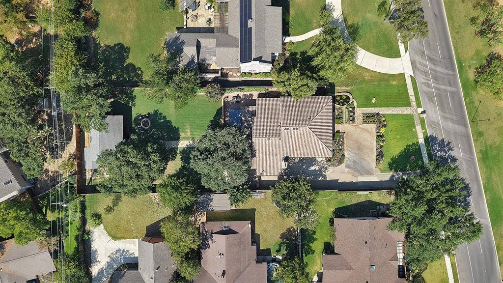 306 E Rochelle Boulevard, Irving, TX 75062 Aerial perspective featuring a lot with a paved driveway, a structured backyard with a pool, a detached storage building, and perimeter fencing
