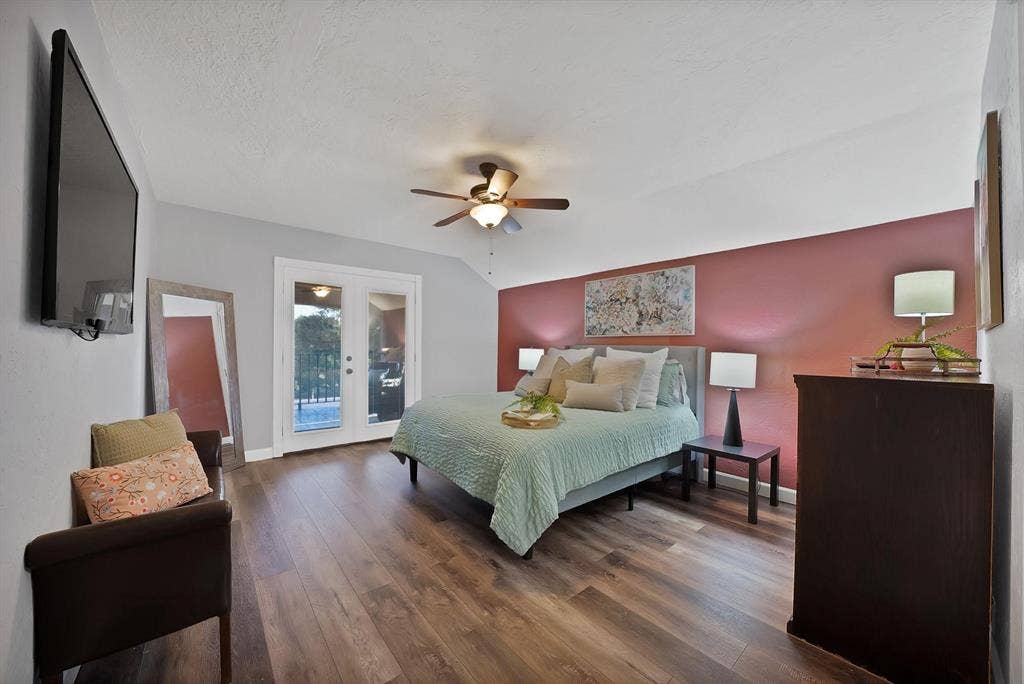 306 E Rochelle Boulevard, Irving, TX 75062 Wood-finish flooring, accent wall, ceiling fan with integrated lighting, and double glass-paned doors