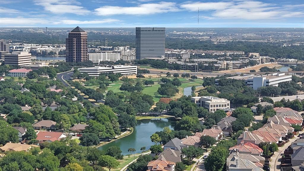306 E Rochelle Boulevard, Irving, TX 75062 Aerial perspective showcasing extensive green space, a central water feature, and high-rise metropolitan surroundings