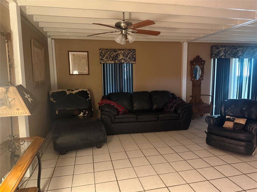 Tile flooring, exposed beam ceiling, and ceiling fan with integrated lighting