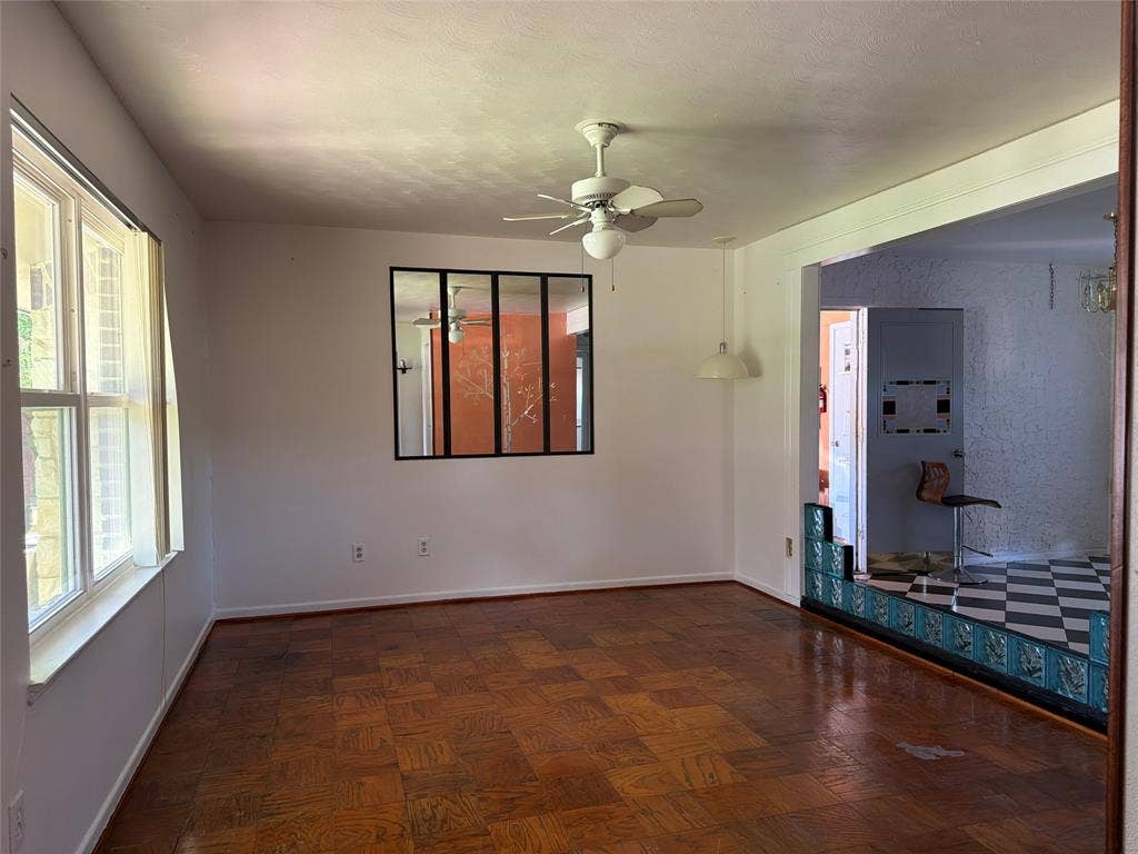 1819 Finley Road, Irving, TX 75062 Parquet wood-finish flooring, interior multi-pane window feature, ceiling fan with integrated light fixture, pendant lighting, and decorative tiled divider wall