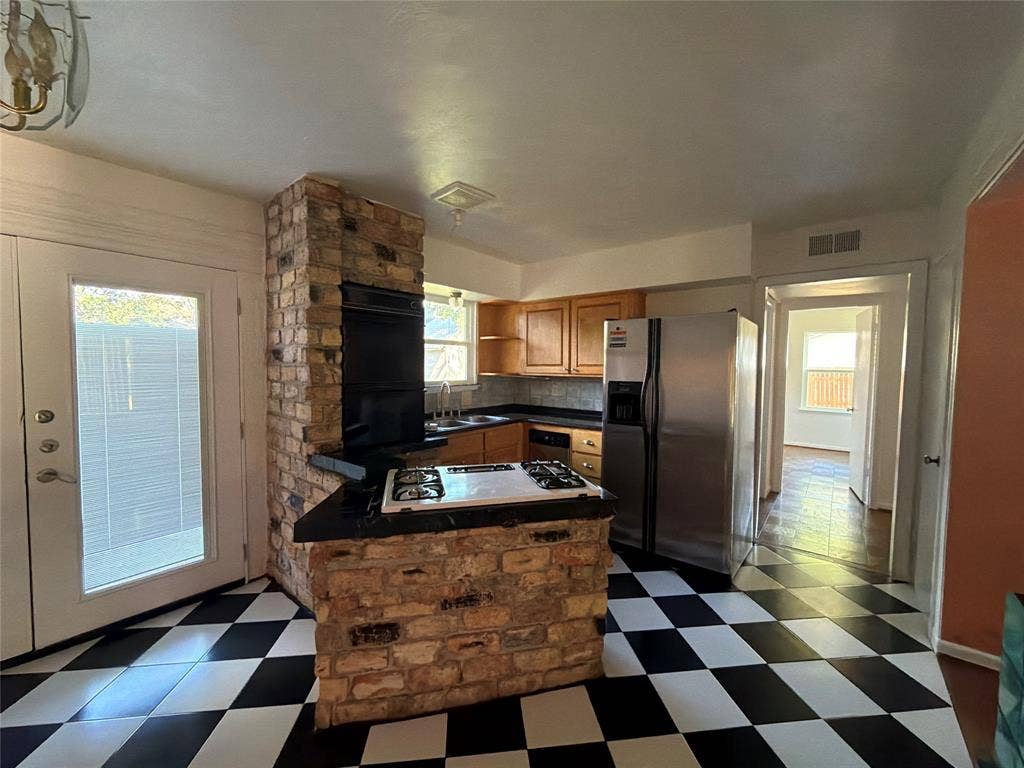 1819 Finley Road, Irving, TX 75062 Kitchen featuring a brick-encased built-in cooktop and oven, wood cabinetry, stone-finish countertops, stainless steel side-by-side refrigerator, and checkerboard tile flooring