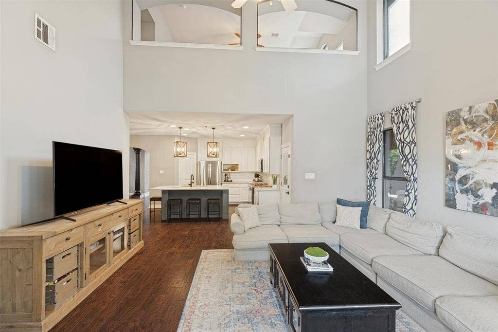 Two-story high ceiling, wood-finish flooring, and recessed lighting