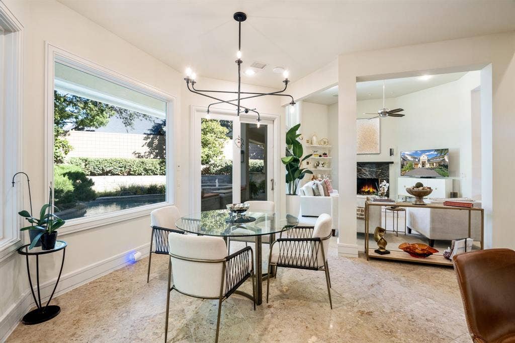 Dining area featuring large-format tile flooring, a multi-arm matte black chandelier, and expansive picture windows