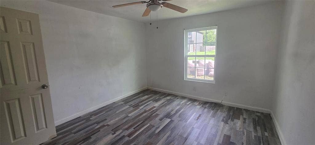 3510 Marshall Street, Greenville, TX 75401 Room featuring wood-finish flooring, a multi-pane window, and a ceiling fan
