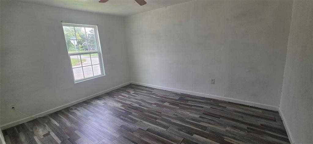 3510 Marshall Street, Greenville, TX 75401 Room featuring wood-finish flooring, a multi-pane window, and a ceiling fan